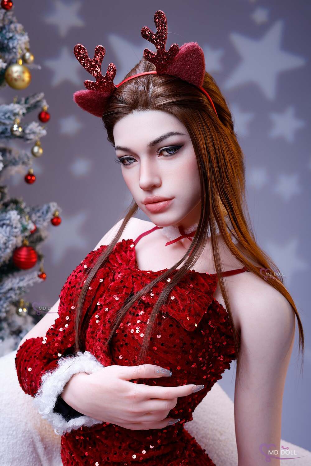 MD Doll Eileen in a red outfit beside a decorated tree